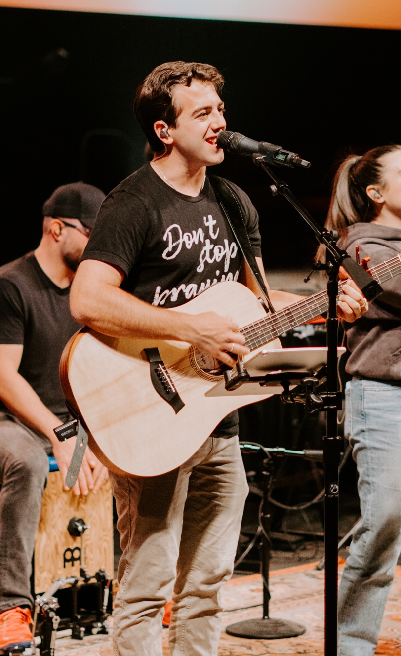 A guy leading worship with a guitar